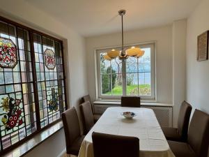 a dining room with a table and stained glass windows at Haus am See in Wasserburg am Bodensee