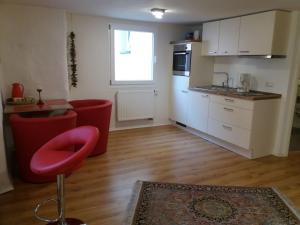 eine Küche mit einem roten Stuhl in einem Zimmer in der Unterkunft Ferienwohnung Luna in Lindau