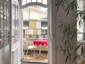a door leading to a patio with a table and a chair at Ferienwohnung am Segelhafen - Altstadtperle direkt am Segelhafen in Lindau