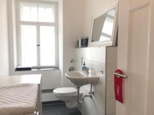 a bathroom with a toilet and a sink and a window at Ferienwohnung am Segelhafen - Altstadtperle direkt am Segelhafen in Lindau +13 photos