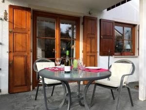 a table with two chairs and a bottle of wine at Ferienwohnung Im schönen Dorf - idyllische Lage mit Terrasse und Garten in Lindau-Bodolz +12 photos
