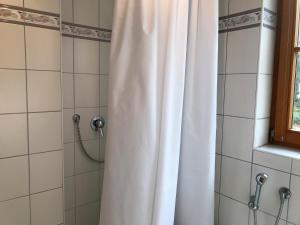 eine Dusche mit einem weißen Duschvorhang im Bad in der Unterkunft Ferienwohnung Vera in Lindau-Bodolz