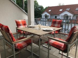 a wooden table and chairs on a balcony at Ferienwohnung am Hopfengarten - helle 2 Zimmer Maisonette mit großem Balkon in Lindau