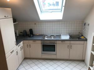 a kitchen with a sink and a stove and a window at Ferienwohnung am Hopfengarten - helle 2 Zimmer Maisonette mit großem Balkon in Lindau +12 photos