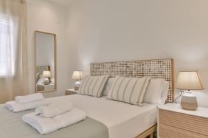 a white bedroom with a large bed with white pillows at LA CALITA- By Almarina Villas in Moraira +52 photos