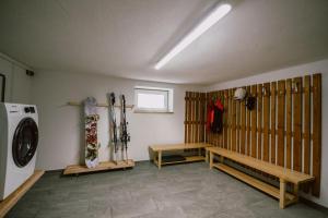 um quarto com esquis na parede e uma máquina de secar roupa em Nedererhof - Zimmer Alpenrose mit Gemeinschaftsküche em Schmirn