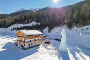 uma vista aérea de um edifício na neve em Nedererhof - Zimmer Alpenrose mit Gemeinschaftsküche em Schmirn