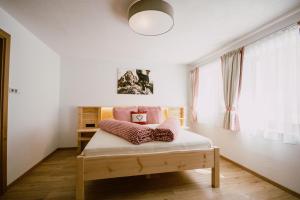 Un dormitorio con una cama con almohadas. en Nedererhof - Zimmer Alpenrose mit Gemeinschaftsküche en Schmirn