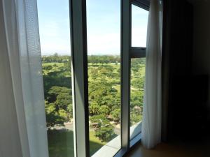 a window with a view of a lush green field at Avant Apartments at The Fort in Manila