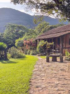 a stone path next to a building with a picnic table at Pousada Grande Pedreira in Serra do Cipo