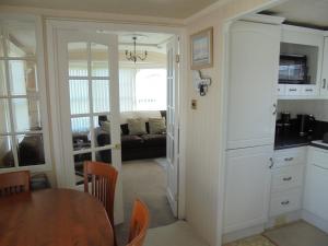 a kitchen and dining room with a table and a couch at Golden Anchor : Ovation 4 Berth, Wrap Around Decking in Chapel Saint Leonards