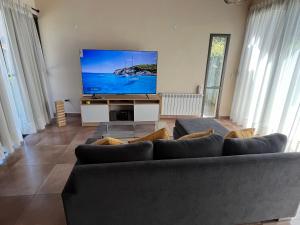a living room with a couch and a flat screen tv at Andelka-Chumamaya Merlo San Luis in Merlo