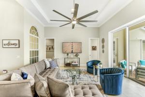 a living room with a couch and a ceiling fan at Modern home w screened pool, hot tub, & comm amenities! in Naples