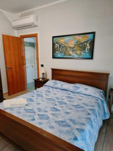 凱拉斯科的住宿－AFFITTACAMERE DOLCE SOGNO，卧室配有一张床,墙上挂有绘画作品