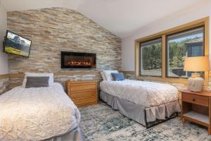 two beds in a bedroom with a brick wall at Lake Forest Lakeview Long Stay Condo: Fantastic Location, Views in Frisco