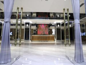 a lobby with columns and a stage in a building at Astra hotel in Qarshi