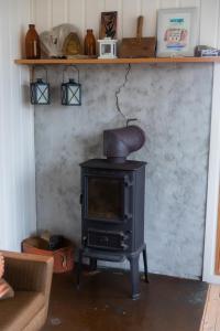 a black stove in a living room with a couch at Cottage with stunning view of the sea and islands. in Leynar
