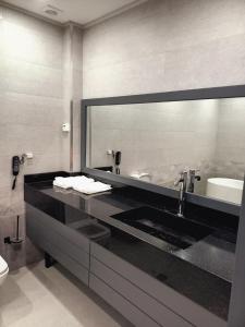 ein Bad mit einem Waschbecken und einem Spiegel in der Unterkunft Astra hotel in Qarshi