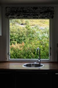 un lavandino da cucina e una finestra con vista di Cottage with stunning view of the sea and islands. a Leynar