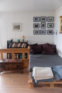 1 dormitorio con 1 cama y 1 mesa con cuadros en la pared en Cottage with stunning view of the sea and islands. en Leynar