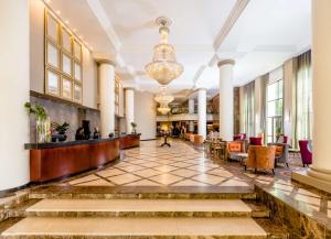 a lobby of a hotel with a reception desk and chairs at Southern Sun Sandton in Johannesburg