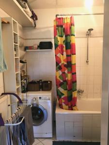 a washing machine in a kitchen with a colorful shower curtain at Alt Treptow Fashion HQ in Berlin