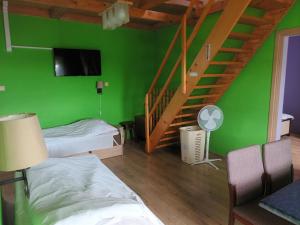 a green room with two beds and a staircase at U Adama in Wieliczka