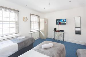 a room with two beds and a table in it at Studio9 Rooms - Next to Emirates Stadium - Budget Rooms with Shared Bathroom in London