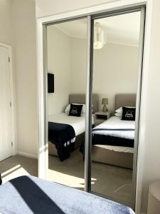 a bedroom with two beds and a mirror at Diddly Squat Lodge with hot tub, Pendle View Holiday Park in Clitheroe