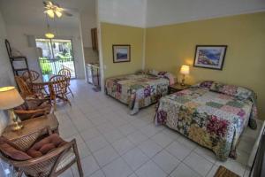 サウス・パドレ・アイランドにあるSandcastle 201B Condominium Condoのベッド2台とテーブルと椅子のある寝室