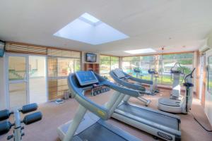 a gym with a row of treadmills and machines at Southern Sun Ridgeway Lusaka in Lusaka