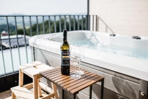 eine Flasche Wein und zwei Weingläser auf dem Tisch in der Unterkunft Stock & Stein Lodges in Bad Gleichenberg