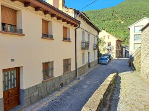 an alley in a town with a car parked on the street at APARTAMENTO CASA COTI in Biescas