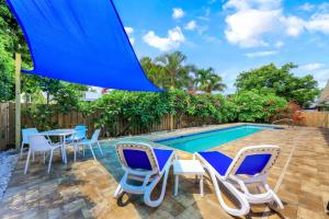 un patio con sillas, una mesa y una piscina en Woodridge - Private Pool, Pet Friendly, 24 Hour Pro-Host Support, en Naples