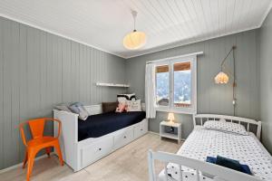 een kleine slaapkamer met een bed en een stoel bij Sunny Design Chalet in Engelberg with spectacular view on Mount Titlis in Engelberg