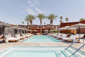 a swimming pool with lounge chairs and a resort at ARRIVE Palm Springs - Adults Only in Palm Springs