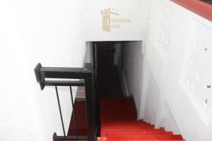 un escalier avec une rampe noire et des escaliers rouges dans l'établissement Marien Inn, à Galle