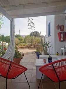 - deux chaises rouges assises sur une terrasse avec vue dans l'établissement Ca n'Antonia Formentera, à Sant Francesc Xavier