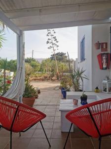 two red chairs sitting on a patio with a view at Ca n'Antonia Formentera in Sant Francesc Xavier