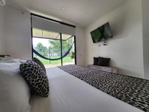 1 dormitorio con cama grande y ventana grande en Amazonia Deluxe Lake Condo, en Leticia