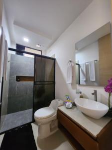 a bathroom with a toilet and a sink and a shower at Amazonia Deluxe Lake Condo in Leticia