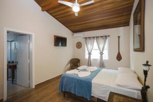 a bedroom with a bed with a wooden ceiling at Solar da Teresa in Búzios
