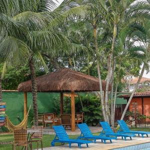 een groep blauwe stoelen en een paviljoen met palmbomen bij Solar da Teresa in Búzios
