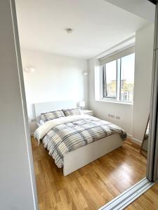a white bedroom with a bed and a window at Holloway Studio in London