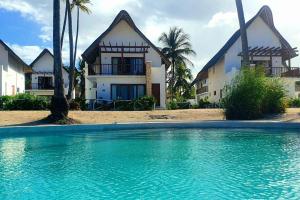 ein Haus und ein Pool vor einem Haus in der Unterkunft Ocean Front Villa with pool, Zanzibar in Pingwe
