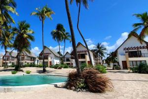 un complexe avec une piscine et des palmiers dans l'établissement Ocean Front Villa with pool, Zanzibar, à Pingwe