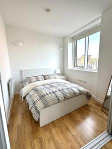 Holloway Studio في لندن: غرفة نوم بيضاء بها سرير ونافذة