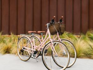 uma bicicleta rosa com duas cestas estacionadas no passeio em ARRIVE Palm Springs - Adults Only em Palm Springs