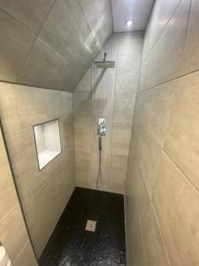 a bathroom with a shower with a phone on the wall at Fantastic 2 bedroom apartment in Sunderland