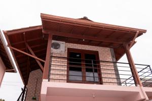 a building with a balcony on top of it at Bangalo da santa in Guarda do Embaú